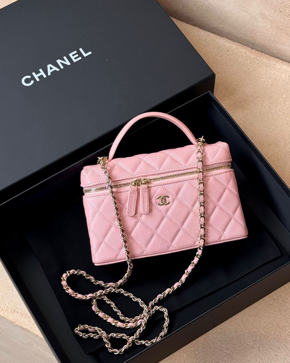pink chanel vanity bag inside a black branded bag